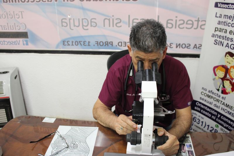 El Dr. Salvador Mercado revisa una muestra en el microscopio del consultorio - VSB Nogales